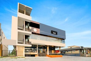 Un immeuble moderne à plusieurs étages, sur lequel on peut lire l’inscription « TOWNHOUSE ».
