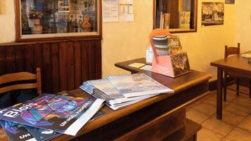 Un comptoir d’accueil avec des magazines, une bouteille d’eau et un tableau encadré au mur.