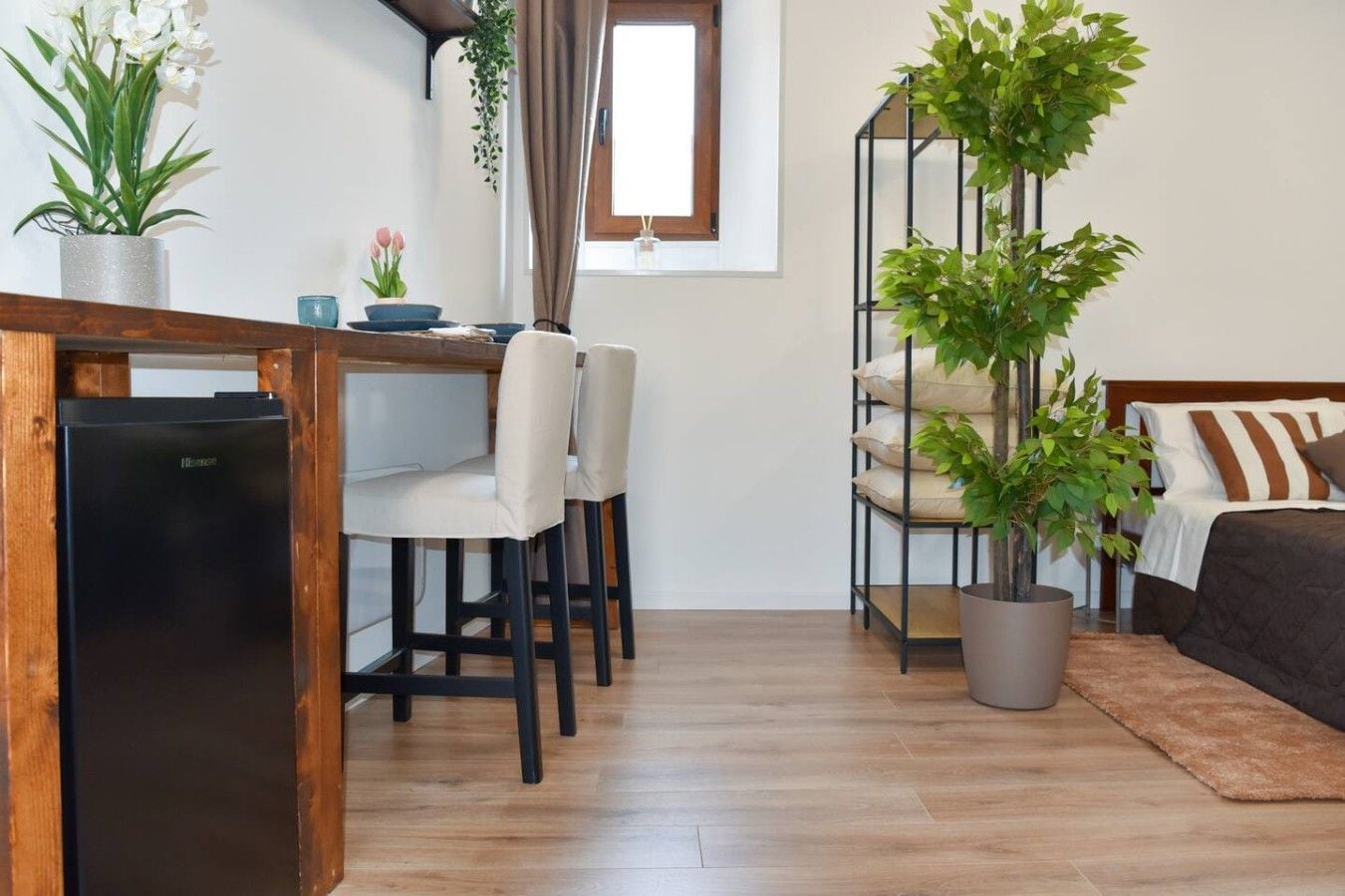 Un espacio habitable compacto con kitchenette, comedor y cama.