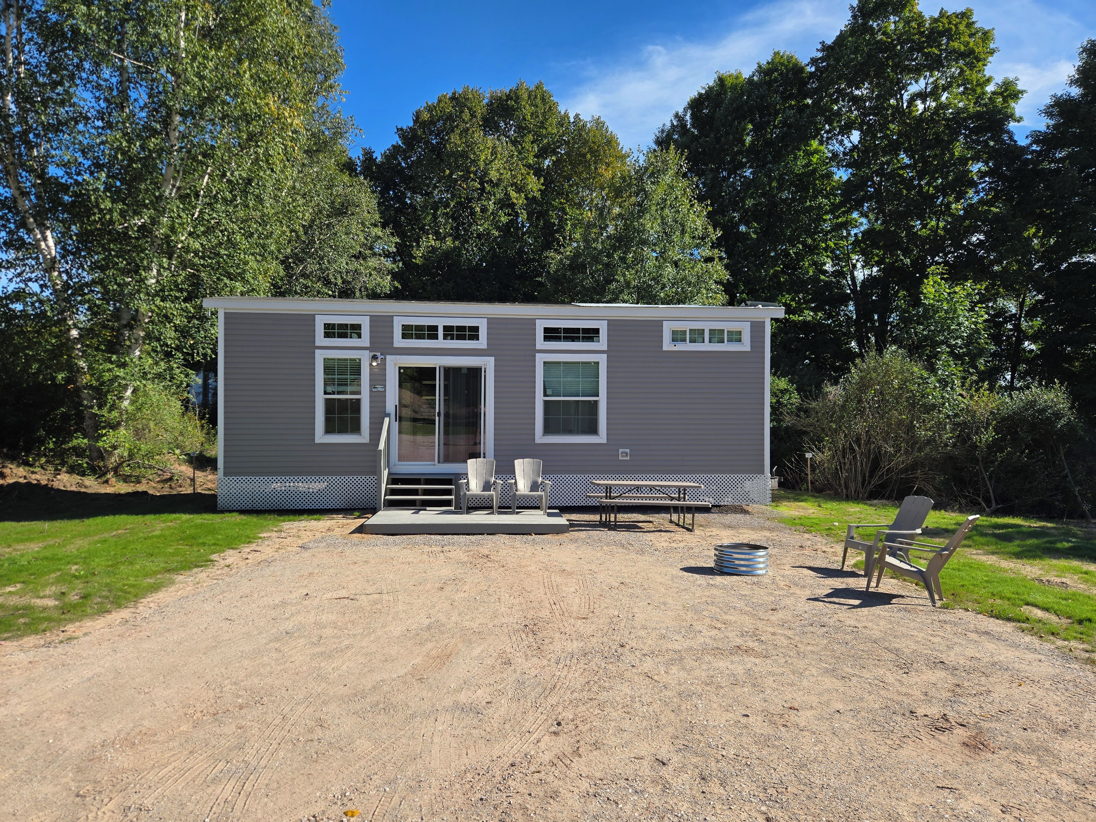 A single-story mobile home with a front porch, two windows, and a door.