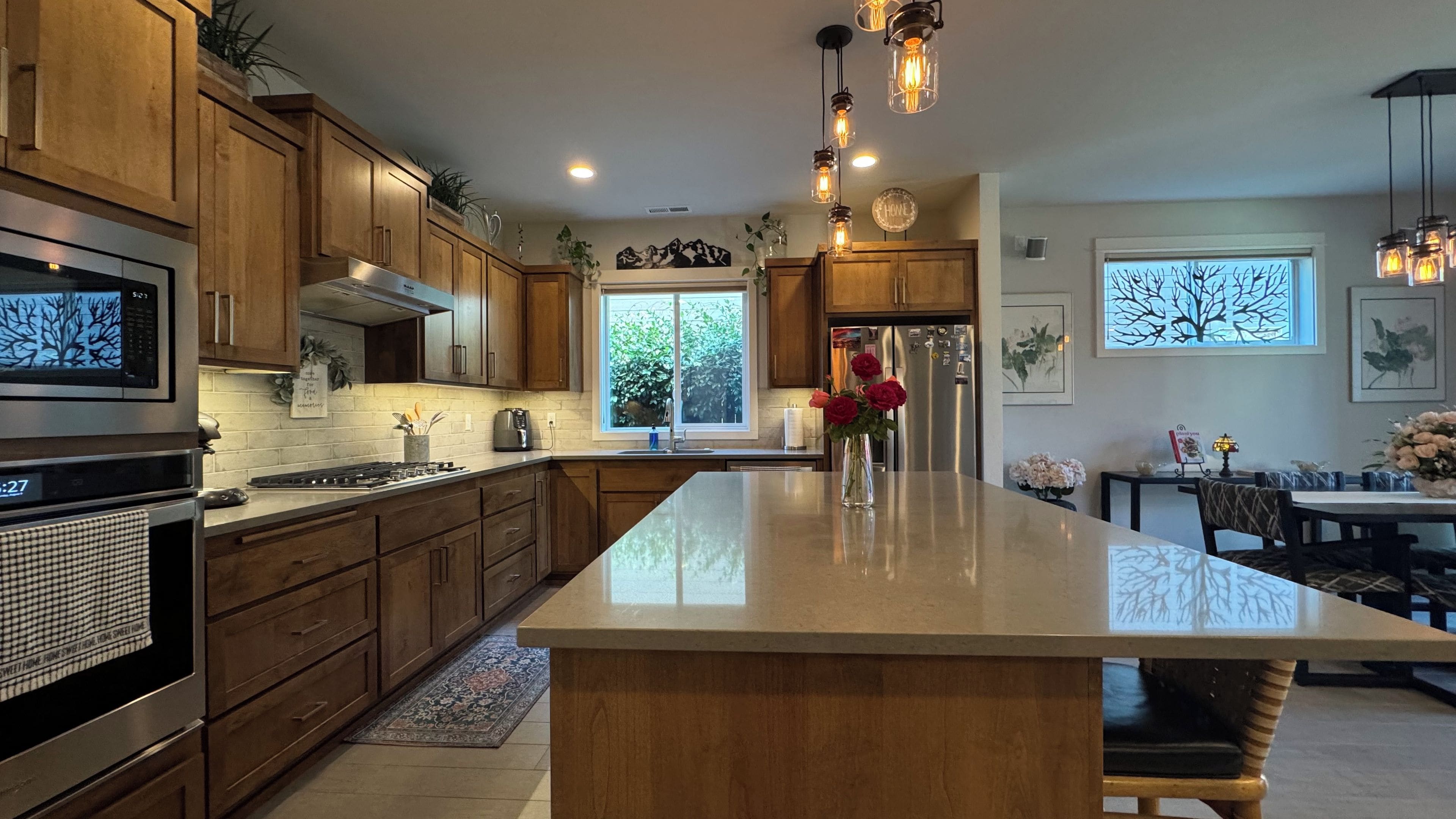 A modern kitchen with wooden cabinets, stainless steel appliances, and a large island.