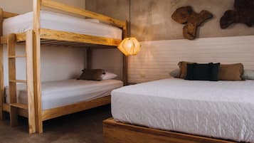 Uma cama box com estrutura de madeira e um colchão de baixo com travesseiro.