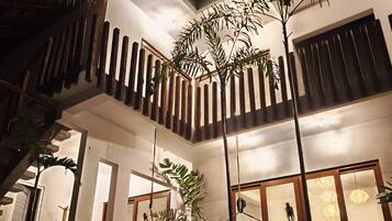 A multi-level residential building with a pool, outdoor plants, and a staircase.