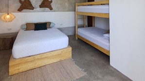 Une chambre avec un lit superposé, un lit simple, un ventilateur de plafond et un appareil de climatisation.