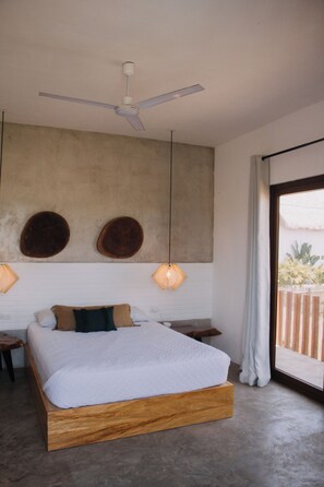 A bedroom with a large bed, a ceiling fan, two wall-mounted lamps, and a view of the outdoors. - Areia Do Sol A/C Private Family Pool Paso MAR (El Paredón Buena Vista)