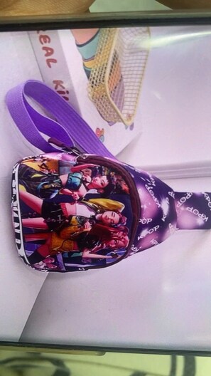 Uma bolsa com um design colorido e uma alça roxa.