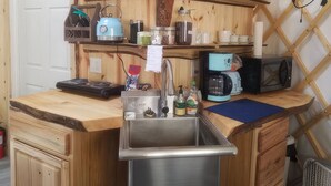 A compact kitchen with a sink, a kettle, a coffee maker, and a microwave. - A cozy yurt with all of the amenities (Big Lake)