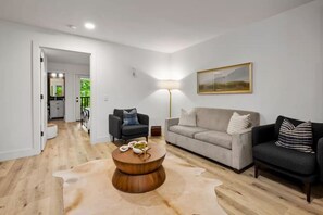 A modern living room with a round coffee table, a sofa, and a chair.