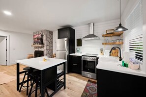A modern kitchen with a central island, a stove, and a refrigerator.
