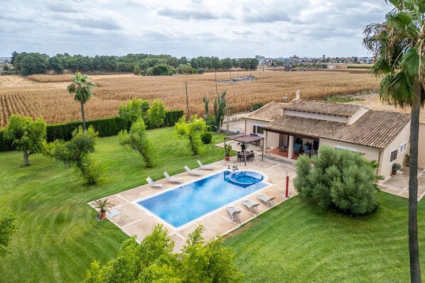 A residential property with a swimming pool, a patio with lounge chairs, and a view of a rural landscape. - Finca with pool Son Crestes, Sa Pobla (Sa Pobla)
