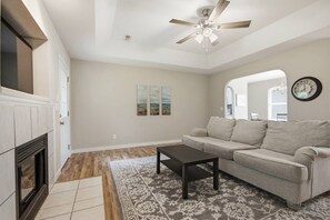 A living room with a fireplace, a ceiling fan, a sofa, and a rug. - Misty Lane Retreat | Walk to Parks & Disc Golf (Ashland)