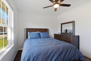 A bedroom with a bed, a dresser, a mirror, and a ceiling fan. - Penny Lane Retreat | 15 Min. to Stadium (Columbia)