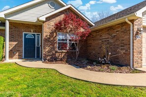 A two-story brick house with a front door, a window with a red-leafed tree, and a mailbox. - Penny Lane Retreat | 15 Min. to Stadium (Columbia)