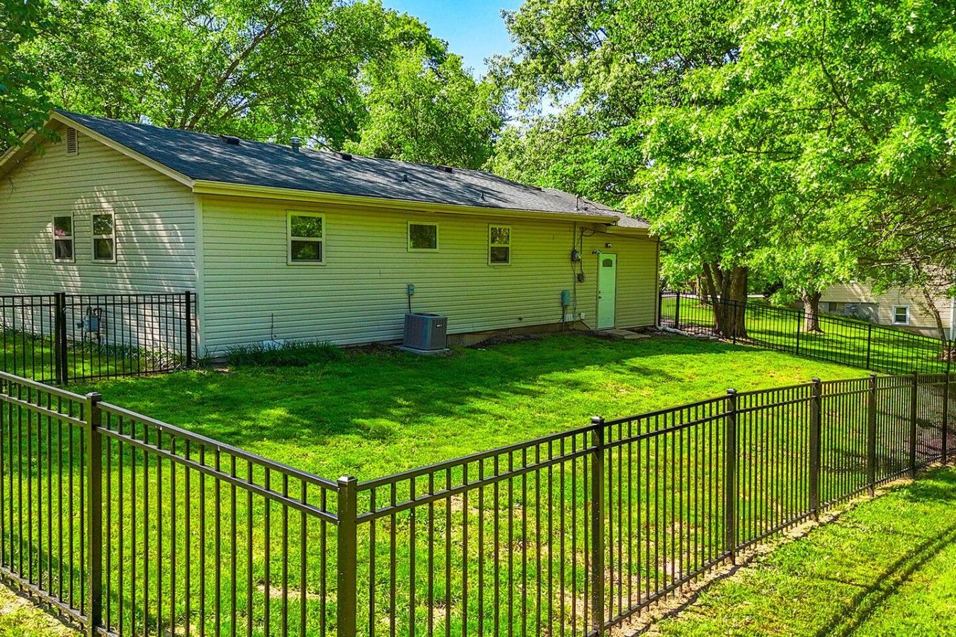 A single-story house with a fenced yard, a small porch, and a garage.