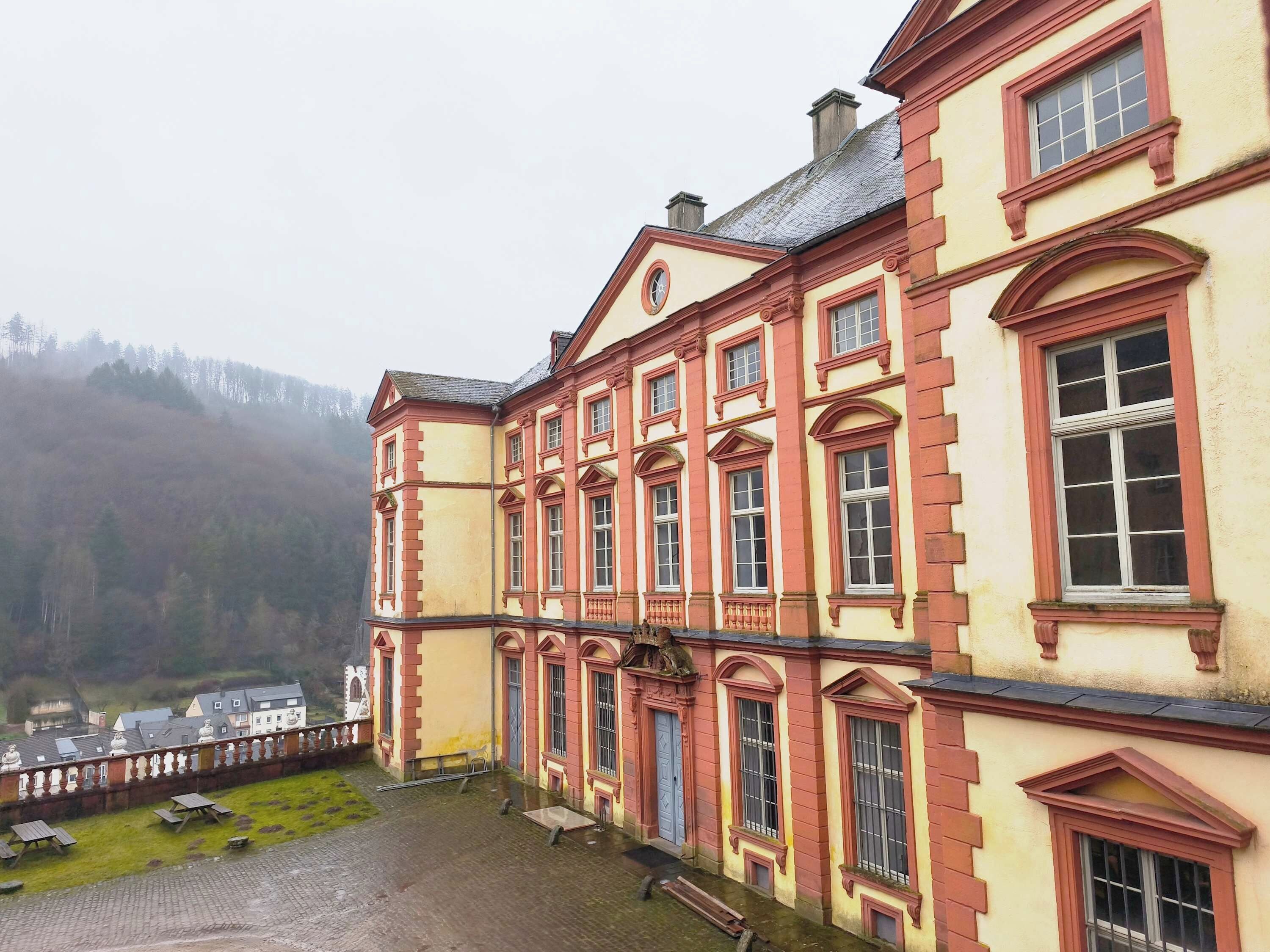 A large, historic building with multiple windows and a courtyard.