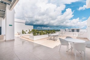 A rooftop terrace with outdoor seating, a view of the sky, and a white building structure. - Apt 3 bedroom 6 guests private jacuzzi (Punta Cana)