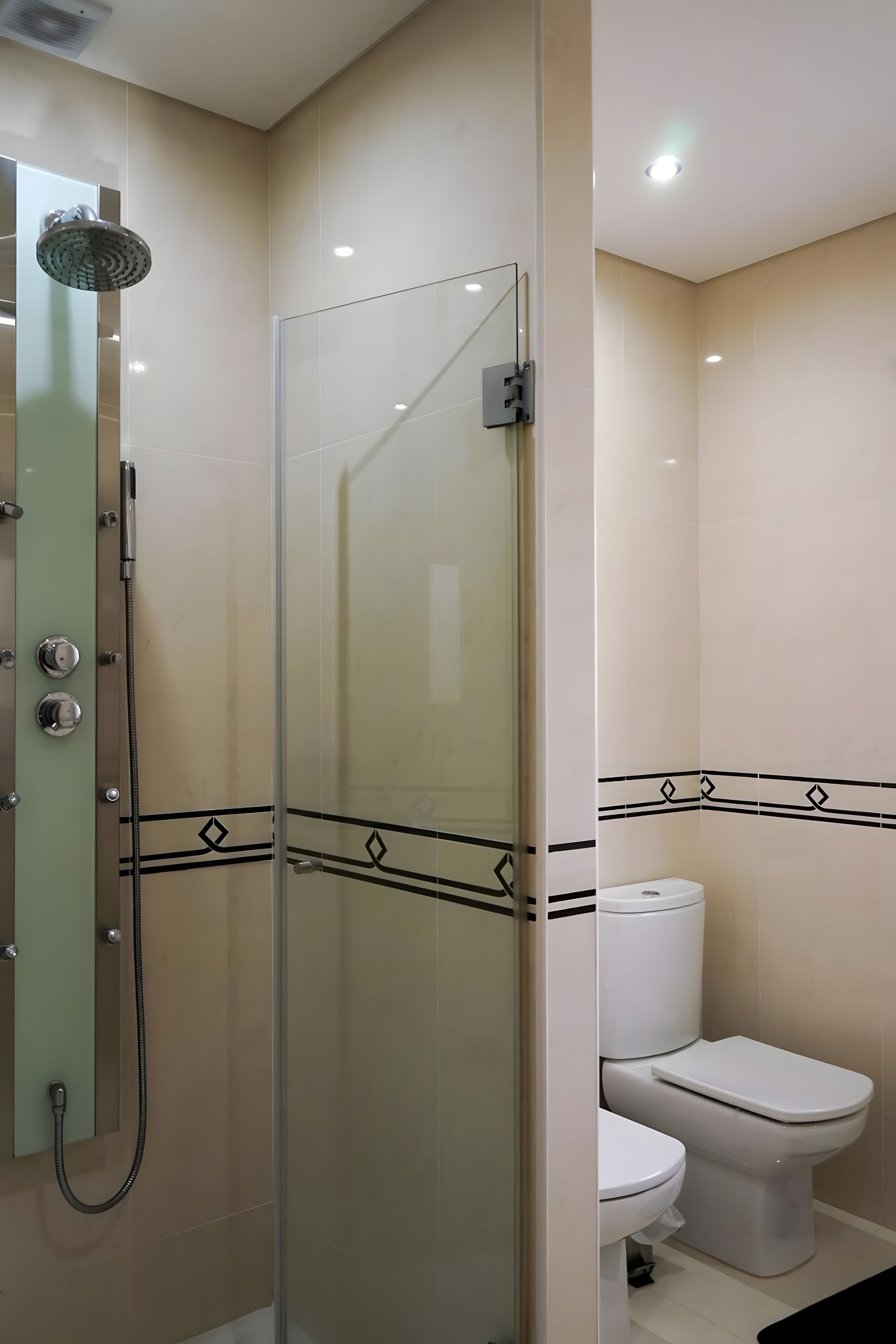 Un baño moderno con ducha envuelta en vidrio, inodoro y lavabo.