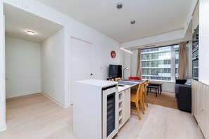 Una cocina moderna con zona de comedor, horno empotrado y un amplio ventanal con vistas a la ciudad.