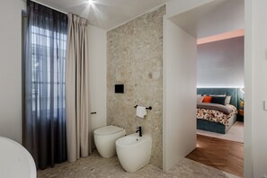 A modern bathroom with a toilet, bidet, and a shower area. - Apartment in Lucca Near Iconic Landmarks (Lucca)
