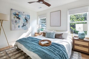 A bedroom with a bed, a window, a ceiling fan, and artwork on the wall. - Beltline Bungalow (Atlanta)