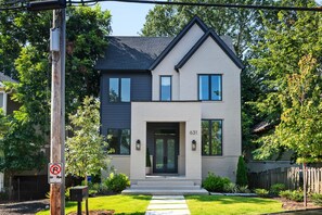 A two-story house with a modern design, featuring a front entrance with a door and windows, and a mailbox. - Beltline Bungalow (Atlanta)