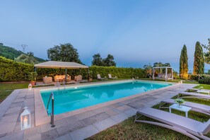 A swimming pool with lounge chairs and a covered seating area. - Villa With Pool and Vineyard Views (Capannori)