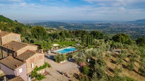 A villa with a swimming pool surrounded by lush greenery and a view of the countryside. - Villa With Pool and Vineyard Views (Capannori)