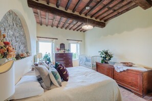 A bedroom with a bed, dresser, and a large window. - Villa With Pool and Vineyard Views (Capannori)