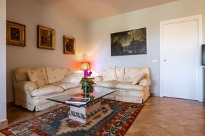 Ein Wohnzimmer mit einer Couch, einem Couchtisch, einem Teppich und Wandbildern.