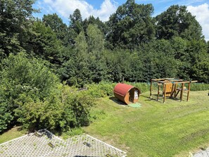 Eine Holzhütte mit rotem Dach, umgeben von üppiger Vegetation und Bäumen.
