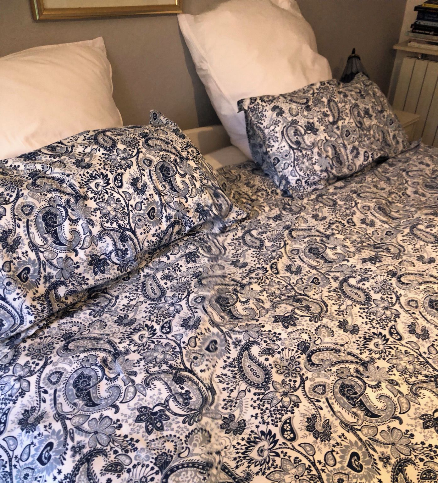 Un lit avec une couvre-lit à motifs et deux oreillers.
