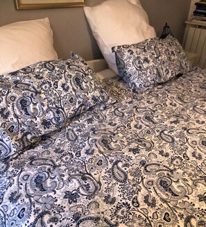 Un lit avec une couvre-lit à motifs et deux oreillers.