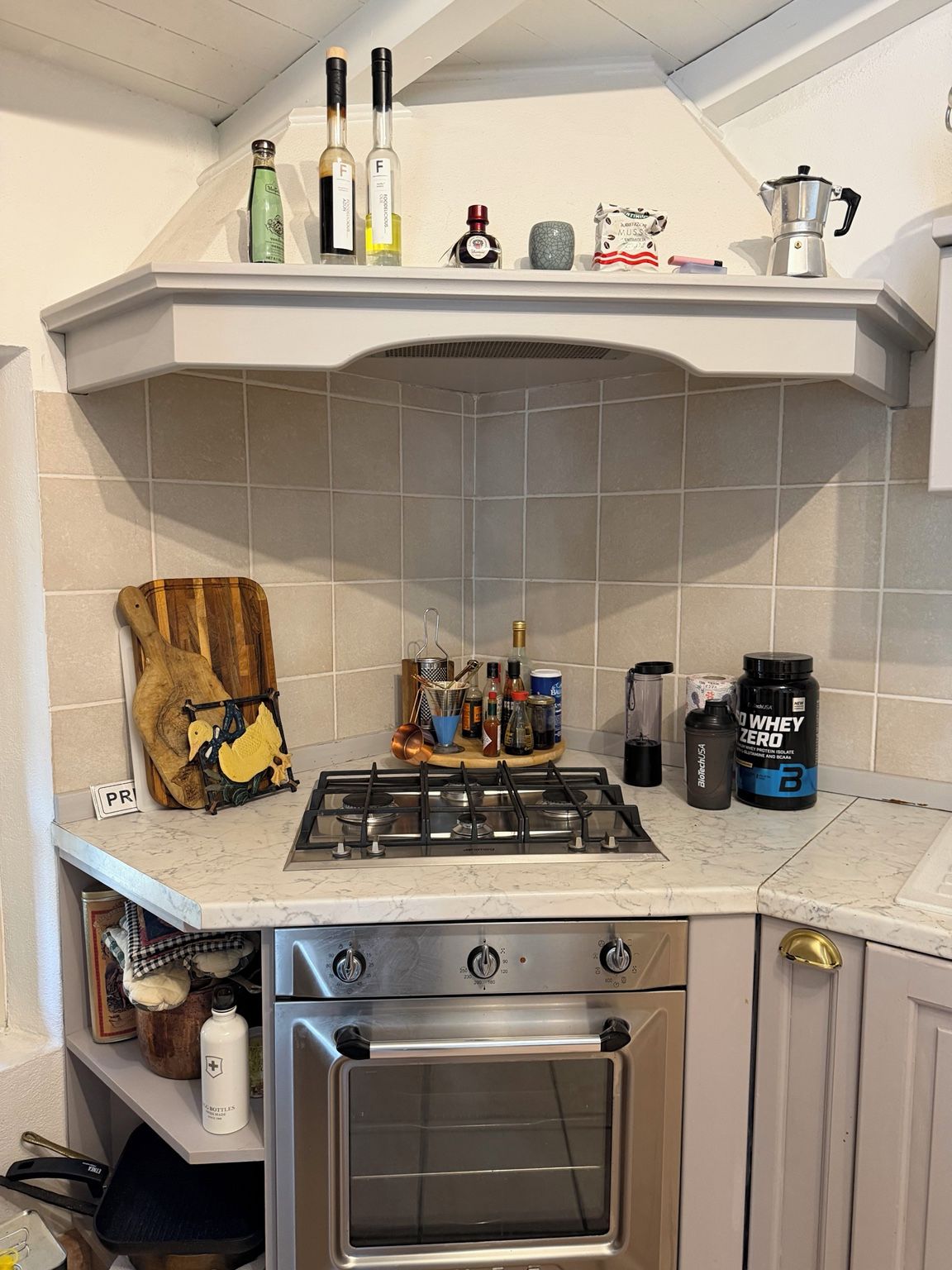Une cuisine équipée d’une cuisinière à gaz, d’un four et de divers ustensiles de cuisine disposés sur le plan de travail.