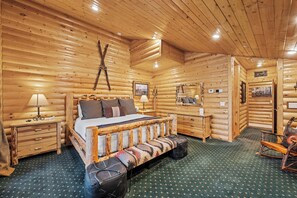 A log cabin bedroom with a bed, bedside tables, a bench, and a rocking chair. - Private Hot Tub | Walk to the Resort (Park City)