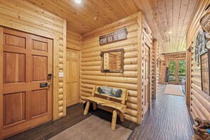 A wooden cabin interior with a bench, a sign instructing to remove ski boots, and a door with a caution sign. - Private Hot Tub | Walk to the Resort (Park City)