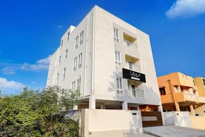 A multi-story building with a sign indicating it is a company-serviced collection. - Super Collection O Sholinganallur (Chennai)