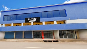 A blue building with a sign that reads 'HOTEL' and 'Company-Sponsored'. - Hotel O Eluru Railway Station (Eluru)