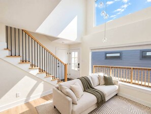 Ein modernes Interieur mit einer Treppe, einem Sofa und Blick zum Himmel.