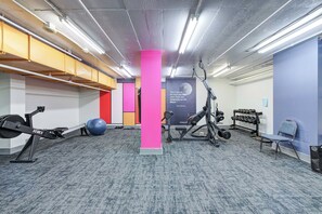 A gym with exercise equipment, a blue exercise ball, and a motivational quote on the wall. - THE COSMOPOLITAN- YXE Penthouse (Saskatoon)