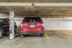 A parking garage with a red Subaru Forester parked in a space marked with the number 41. - THE COSMOPOLITAN- YXE Penthouse (Saskatoon)