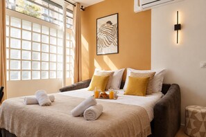 A hotel room with a bed, pillows, a bedside table with a tray of breakfast, and a window with curtains. - TheBlueStay 365 - Beautiful A/C Apartment in Paris (Paris)