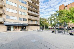 Een meerlaags hotel met een platte gevel, een terras en een hekwerk.