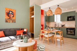 A modern living space with a sofa, dining table, and kitchen area. - TheBlueStay 369 - Beautiful A/C Apartment in Paris (Paris)