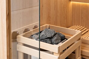 A sauna with wooden benches and a stone-filled basin. - TheBlueStay 368 - Beautiful A/C Apartment in Paris (Paris)