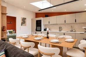 A modern dining area with a wooden table set for a meal, surrounded by chairs. - TheBlueStay 368 - Beautiful A/C Apartment in Paris (Paris)