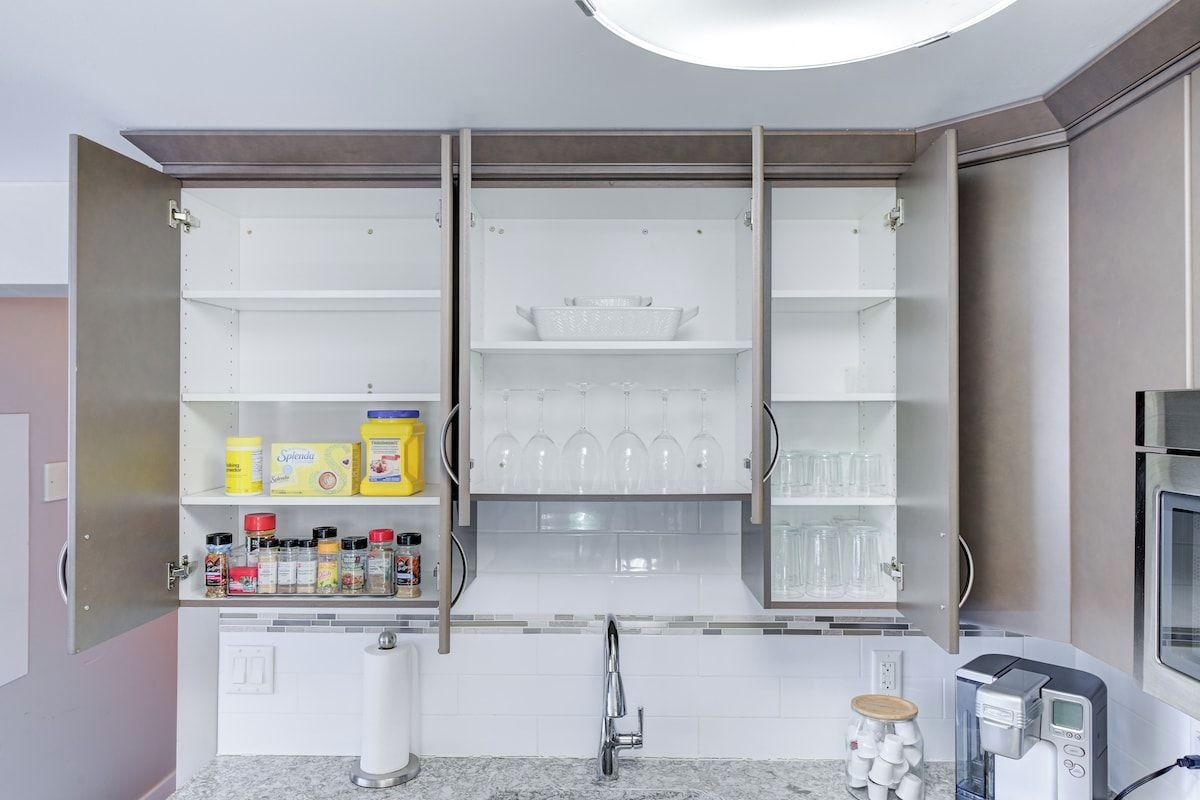 A kitchen with a built-in microwave, a coffee machine, and a wine rack.