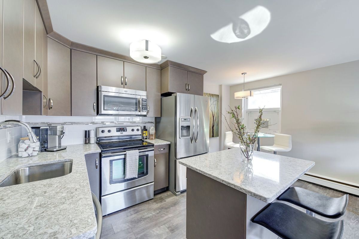 A modern kitchen with stainless steel appliances, a granite countertop, and a built-in oven.