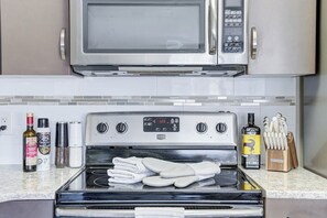 Une cuisine équipée d’un four à micro-ondes, d’un four traditionnel et de divers ustensiles de cuisine.