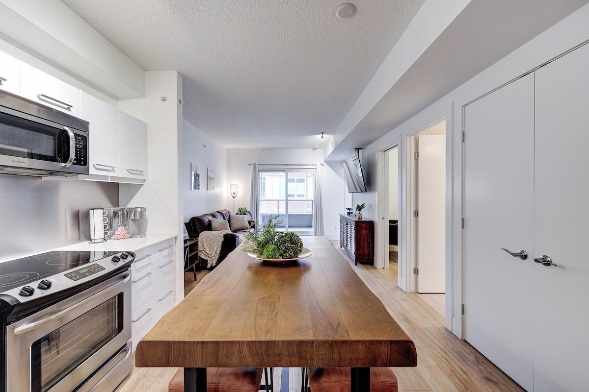 A modern kitchen with a central island, built-in appliances, and a view to the living area.