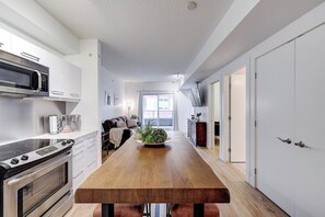Une cuisine moderne dotée d’un îlot central, d’appareils électroménagers intégrés et offrant une vue sur l’espace de vie.